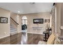 Open-concept living room with hardwood floors, staircase, and view into the kitchen at 10230 Danskin Dr, Las Vegas, NV 89166