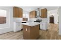 Modern kitchen with white and wood cabinets, stainless steel appliances, and a center island at 10540 Beachwalk Pl, Las Vegas, NV 89144