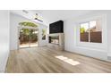 Bright living room with fireplace feature wall, wood-look floors, and sliding glass door to backyard at 10540 Beachwalk Pl, Las Vegas, NV 89144