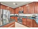 Gourmet kitchen featuring stainless steel appliances, granite countertops, and a gas cooktop range at 11908 Menchaca Ln, Las Vegas, NV 89138