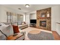 Bright living room features a cozy stone fireplace, neutral color scheme, and lots of natural light at 11908 Menchaca Ln, Las Vegas, NV 89138