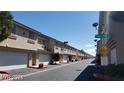 Exterior view of condo building units with private garages, lush landscaping and street signage at 1236 Dusty Creek St, Las Vegas, NV 89128