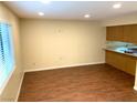 Bright living room with wood floors and a window with a kitchen in the background at 1316 Capri Dr # Abc&D, Boulder City, NV 89005
