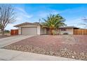 Charming single-story home featuring a desert-landscaped yard, a large palm tree, and an attached two-car garage at 2559 Winterwood Blvd, Las Vegas, NV 89142