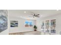 Bright living room with modern ceiling fan, fresh paint, neutral accents, and sliding door access to the backyard at 2559 Winterwood Blvd, Las Vegas, NV 89142