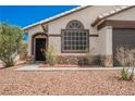 Close up of front door and window with decorative stone and desert landscaping at 2860 Galena Peak Ln, Las Vegas, NV 89156