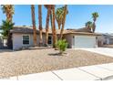 Single-story home with a two-car garage, desert landscaping and an inviting, well-maintained front yard at 3143 La Mesa Dr, Henderson, NV 89014
