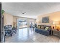 Inviting living room with neutral paint, tile flooring, comfortable seating and sliding glass door to the backyard at 3143 La Mesa Dr, Henderson, NV 89014