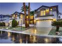 Beautiful home at dusk features a well-lit three-car garage and meticulously landscaped front yard with palm trees at 386 Wiseton Ave, Las Vegas, NV 89183
