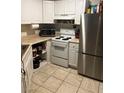 Cozy kitchen featuring white cabinets, neutral countertops, and stainless steel refrigerator at 520 Elm Dr # 202, Las Vegas, NV 89169