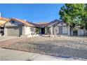 Single story house featuring low maintenance landscaping and a red tile roof at 6771 Shelter Ln, Las Vegas, NV 89103
