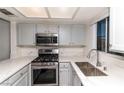 Updated kitchen featuring stainless steel appliances, light gray cabinetry, and white marble countertops at 7100 Pirates Cove Rd # 2065, Las Vegas, NV 89145