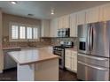 Bright kitchen with stainless steel appliances, island, and mosaic backsplash at 7257 Early Pioneer Ave, Las Vegas, NV 89129
