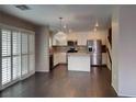 Bright, updated kitchen with island, stainless appliances, and a modern chandelier at 7257 Early Pioneer Ave, Las Vegas, NV 89129