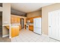Bright kitchen featuring tile flooring, white appliances, and oak cabinets at 8205 Harrogate Ave, Las Vegas, NV 89129