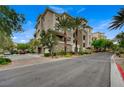 A street-level view of the building showcasing multiple floors and well-maintained landscaping at 9201 Tesoras Dr # 401, Las Vegas, NV 89144