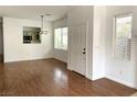 Open-concept living space with wood floors, windows for natural light, and a view into the updated kitchen at 9236 Canalino Dr, Las Vegas, NV 89134