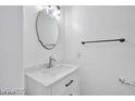 Bathroom featuring an oval mirror, white vanity, and modern fixtures against a clean, neutral backdrop at 9247 Tulip Trestle Ave, Las Vegas, NV 89148