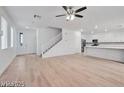 Open living area boasts light wood floors, multiple windows, and a modern ceiling fan for a bright, spacious feel at 9247 Tulip Trestle Ave, Las Vegas, NV 89148