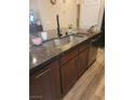 This kitchen features granite counters, a stainless sink, and dark wood cabinets at 9589 Comiskey Ct, Las Vegas, NV 89148