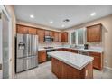 Well-lit kitchen features tile countertops, stainless steel appliances, and wooden cabinets at 9893 Santa Ponsa Ct, Las Vegas, NV 89178