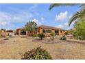 Serene backyard featuring desert landscaping including gravel, various trees, and a covered patio at , Las Vegas, NV 89113