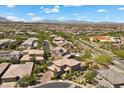 Expansive aerial view of a residential neighborhood with houses, roads and landscaping near mountains at 10470 Dove Meadow Way, Las Vegas, NV 89135