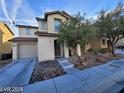 Inviting two-story home with a well-maintained lawn, desert landscaping, and an attached one car garage at 11882 Snow Bank St, Las Vegas, NV 89183