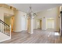 Spacious living room featuring light-colored walls, laminate floors, and a large chandelier at 153 Cascade Lake St, Las Vegas, NV 89148