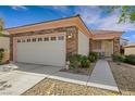 Attractive single-story home with a two-car garage and desert landscaping, creating a low-maintenance yard at 2485 Jade Sky St, Henderson, NV 89044