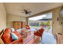 Inviting covered patio with comfortable seating, ceiling fan, and views of the backyard at 2637 Via Monet, Henderson, NV 89044