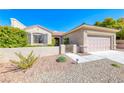 Charming one-story house with a neutral exterior, complemented by a two-car garage, inviting curb appeal, and xeriscaped front yard at 2702 Grand Forks Rd, Henderson, NV 89052