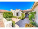 Beautiful home exterior featuring a paved courtyard, neutral tones, complemented by mature landscaping and a tiled roof at 2702 Grand Forks Rd, Henderson, NV 89052