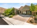 Lovely home with a three-car garage, beautiful desert landscaping, and a brick driveway at 2927 The Peaks Ln, Las Vegas, NV 89138