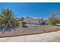 Low angle shot of a single-story house with desert landscaping and a tiled roof at 3912 Branchwood Dr, North Las Vegas, NV 89032