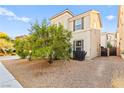 Two-story home with neutral stucco exterior, desert landscaping, dark shutters, and wrought iron side gate at 4533 Lime Straight Dr, Las Vegas, NV 89115