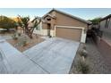 Home with concrete driveway and desert landscaping at 5019 Quiet Falls Ct, Las Vegas, NV 89141