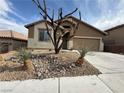 Inviting single-story home with a two-car garage and desert landscaping at 5019 Quiet Falls Ct, Las Vegas, NV 89141