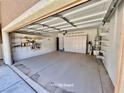 Spacious two-car garage boasts ample shelving for storage, keeping your space organized at 5019 Quiet Falls Ct, Las Vegas, NV 89141