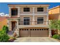 Two-story home with neutral stucco, decorative pillars, wrought iron balcony, and a two-car garage at 5448 Tulip Hill Ave, Las Vegas, NV 89141