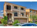 Two-story home featuring a spacious two car garage, entryway steps, and a small balcony at 5448 Tulip Hill Ave, Las Vegas, NV 89141