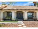 Inviting front porch with double doors, a cozy bench, and attractive landscaping at 5912 Hollowridge Rd, North Las Vegas, NV 89031