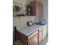 Storage area with wood cabinets, laminate countertops, and decor at 626 Kimberly Ave, Pahrump, NV 89060