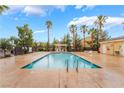 Community pool with palm trees and ample lounging space for residents at 6312 Snap Ridge St # 101, North Las Vegas, NV 89081