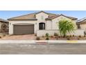 Elegant single-story home featuring a tile roof, two-car garage, and desert-friendly landscaping at 717 Monroe Hill Pl, Henderson, NV 89011