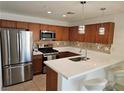 Well-lit kitchen featuring stainless steel appliances, a breakfast bar, and pendant lighting at 7461 Enviable Ct, Las Vegas, NV 89149