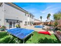 Spacious backyard with lush green grass, pool, and outdoor entertainment area at 7492 Midfield Ct, Las Vegas, NV 89120