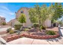 A side view of a two-story home with a well-landscaped yard, featuring trees, shrubs, and decorative brick edging at 7909 Citrus Meadow Ct, Las Vegas, NV 89131