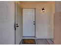 A welcoming front door with a 'Home Sweet Home' doormat and a stylish exterior light fixture at 7909 Citrus Meadow Ct, Las Vegas, NV 89131