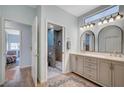 Bright bathroom featuring double sinks, arched mirrors, updated vanity, and a tiled walk-in shower at 8525 Festival Dr, Las Vegas, NV 89134